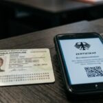 Personalausweis und Smartphone mit digitalem Führungszeugnis als PDF